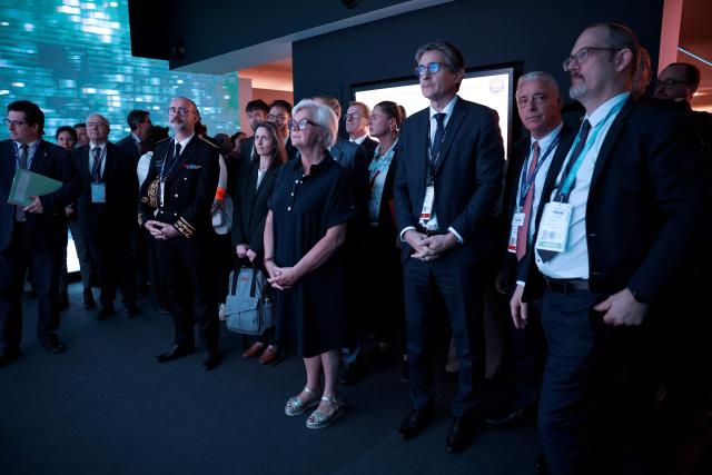 France's Defence Minister Catherine Vautrin (C) stands next to Chief Executive Officer of French aerospace and defence group Thales, Patrice Caine (3rdR) at the Thales stand at the Eurosatory land and airland defence and security trade fair, at the Paris-Nord Villepinte Exhibition Centre in Villepinte, north of Paris, on June 15, 2026. (Photo by Guillaume BAPTISTE / AFP)