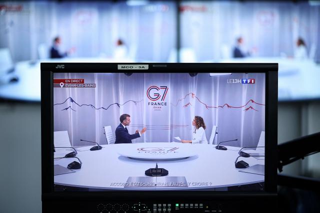 This photograph shows monitors in a media control room at AFP headquarters in Paris displaying France's President Emmanuel Macron (L) speaking with French TV host and journalist Marie-Sophie Lacarrau during an interview as part of French TV channel TF1's news broadcast on the sidelines of the G7 summit, in Evian, central-eastern France on June 15, 2026. A G7 summit is set to take place June 15 to 17 in the French town of Evian-les-Bains near Switzerland and it will be attended by country leaders as well as the EU's foreign policy chief and ministers from Brazil, Canada, the United Arab Emirates and Turkey. (Photo by SIMON WOHLFAHRT / AFP)