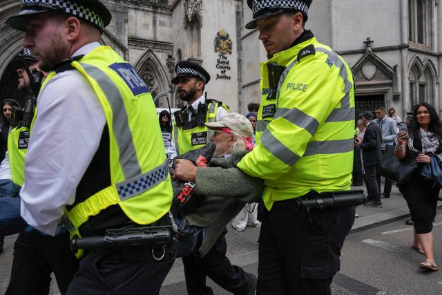 Police remove protesters from outside the Royal Courts Of Justice in central London on June 15, 2026, as the High Court ruled on a legal standoff between the government and activist group Palestine Action. London's Court of Appeal on June 15 upheld a government ban on the Palestine Action activist group imposed under terrorism legislation, following a legal challenge. (Photo by CARLOS JASSO / AFP)