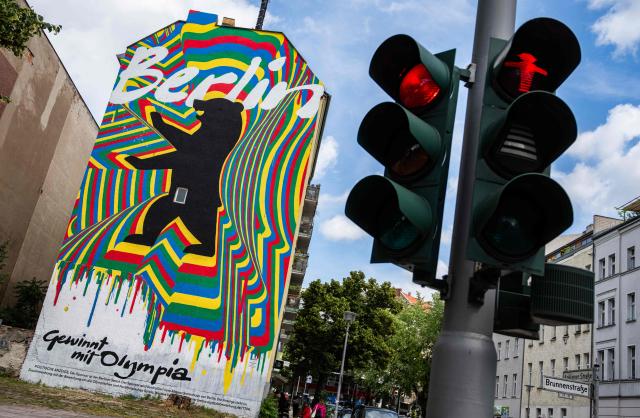 A mural, part of the city of Berlin's campaign to host the Olympic Games in 2036, 2040, or 2044, reads: "Berlin wins with Olympia", is seen next to a traffic light in Berlin on June 15, 2026. (Photo by John MACDOUGALL / AFP)