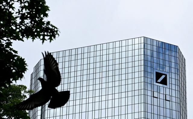 A bird flies past the logo of Deutsche Bank seen on the facade of one of the bank's twin towers, in the banking district of Frankfurt am Main, western Germany, on June 15, 2026. (Photo by Kirill KUDRYAVTSEV / AFP)