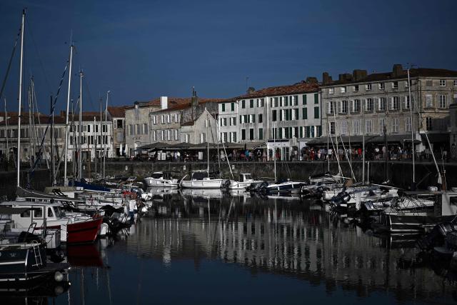 This aerial photograph shows boats moored at a marina surrounding a little island in Saint-Martin-de-Ré, on the northern shore of the Ré island along the Atlantic Ocean, southwestern France on June 13, 2026. The marina consists in a circular tidal basin protected by a lock and shelters up to 280 boats. (Photo by Christophe ARCHAMBAULT / AFP)