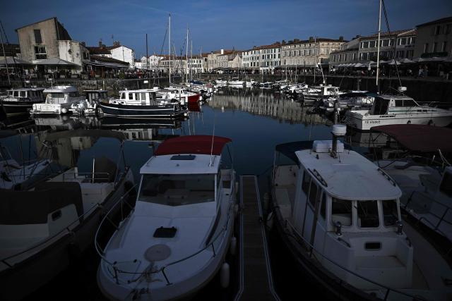 This aerial photograph shows boats moored at a marina surrounding a little island in Saint-Martin-de-Ré, on the northern shore of the Ré island along the Atlantic Ocean, southwestern France on June 13, 2026. The marina consists in a circular tidal basin protected by a lock and shelters up to 280 boats. (Photo by Christophe ARCHAMBAULT / AFP)