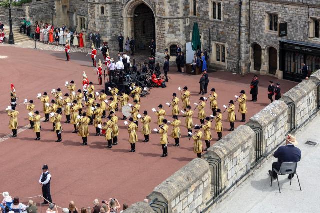A spectator (bottom R) watches the Household Cavalry Band members perform ahead of the annual Order of the Garter service at St. George's Chapel in Windsor Castle, west of London, on June 15, 2026. The Order of the Garter is the oldest and most senior Order of Chivalry in Britain, established by King Edward III nearly 700 years ago. (Photo by Toby Shepheard / POOL / AFP)