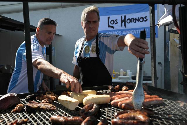 Workers prepare chorizos asados at "Los Hornos" restaurant that caters Argentinian barbecue specialties, near Kansas City, Missouri, United States on June 14, 2026, ahead of the 2026 World Cup football match between Argentina and Algeria. (Photo by JUAN MABROMATA / AFP)