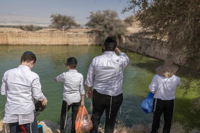 Israelis gather at the ancient archaeological site of "Herod’s Pool" near the Jewish settlement of Petzael, in the Israeli occupied Palestinian West Bank, in the Jordan Valley, after water was recently diverted into the site from a nearby spring on June 15, 2026. Israeli officials are examining the unauthorized works and water diversion by Israeli settlers who have reportedly taken control of the archaeological site and diverted water from Palestinian farmland to fill the ancient pool. (Photo by ilia YEFIMOVICH / AFP)