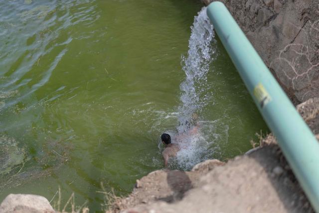 An Israelis cools off in the ancient archaeological site of "Herod’s Pool" near the Jewish settlement of Petzael, in the Israeli occupied Palestinian West Bank, in the Jordan Valley, after water was recently diverted into the site from a nearby spring on June 15, 2026. Israeli officials are examining the unauthorized works and water diversion by Israeli settlers who have reportedly taken control of the archaeological site and diverted water from Palestinian farmland to fill the ancient pool. (Photo by ilia YEFIMOVICH / AFP)