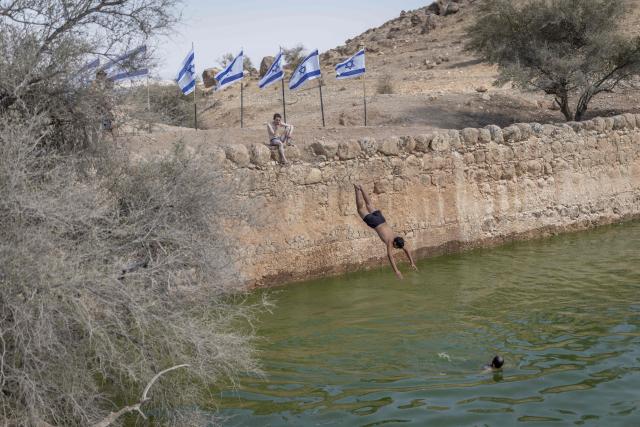 An Israeli dives into the waters of the ancient archaeological site of "Herod’s Pool" near the Jewish settlement of Petzael, in the Israeli occupied Palestinian West Bank, in the Jordan Valley, after water was recently diverted into the site from a nearby spring, on June 15, 2026. Israeli officials are examining the unauthorized works and water diversion by Israeli settlers who have reportedly taken control of the archaeological site and diverted water from Palestinian farmland to fill the ancient pool. (Photo by ilia YEFIMOVICH / AFP)