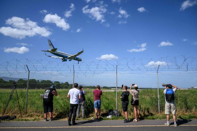 Plane spotters photograph Air Force One aircraft landing at the Geneva Airport ahead of the G7 summit, in Geneva on June 15, 2026. A G7 summit is set to take place June 15 to 17 in the French town of Evian-les-Bains near Switzerland and it will be attended by country leaders as well as the EU's foreign policy chief and ministers from Brazil, Canada, the United Arab Emirates and Turkey. (Photo by Fabrice COFFRINI / AFP)
