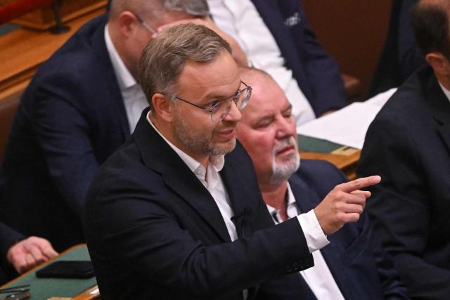Balazs Orban, former political director to former Prime Minister Viktor Orban (not pictured) gestures during his discussion with Prime Minister Peter Magyar (not pictured) as  lawmakers of the Hungarian Parliament prepare to vote on an amendment to the constitution by introducing term-limits for prime ministers to a maximum of eight years in office, in the main hall of the Parliament building in Budapest, on June 15, 2026. Hungarian lawmakers on June 15 voted overwhelmingly to limit prime ministers' terms in office to a maximum of eight years, a constitutional change that blocks nationalist Viktor Orban's return. (Photo by Attila KISBENEDEK / AFP)