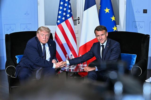 US President Donald Trump (L) shakes hands with France's President Emmanuel Macron during a bilateral meeting on the sidelines of the G7 summit, in Evian, central-eastern France on June 15, 2026. A G7 summit is set to take place June 15 to 17 in the French town of Evian-les-Bains near Switzerland and it will be attended by country leaders as well as the EU's foreign policy chief and ministers from Brazil, Canada, the United Arab Emirates and Turkey. (Photo by Mandel NGAN / AFP)