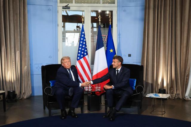 US President Donald Trump (L) shakes hands with France's President Emmanuel Macron during a bilateral meeting on the sidelines of the G7 summit, in Evian, central-eastern France on June 15, 2026. A G7 summit is set to take place June 15 to 17 in the French town of Evian-les-Bains near Switzerland and it will be attended by country leaders as well as the EU's foreign policy chief and ministers from Brazil, Canada, the United Arab Emirates and Turkey. (Photo by Ludovic MARIN / POOL / AFP)