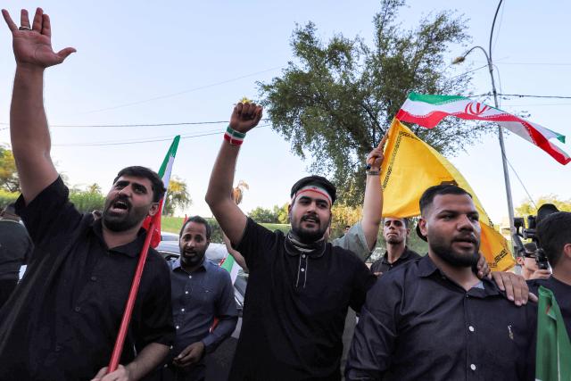 People gather waving flags of Iran and others near the Iranian embassy headquarters in Baghdad on June 15, 2026, during celebrations following the announcement of a deal to end the war between Iran and the US. The US president said on June 15 that the Strait of Hormuz would be fully open later in the week, after Washington and Tehran announced a deal to end the Middle East war. Iran had blockaded the vital waterway since the start of the conflict after US-Israeli strikes on the Islamic republic in late February. (Photo by AHMAD AL-RUBAYE / AFP) / 