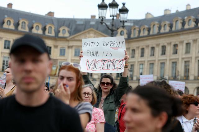 A protestor holds a slogan reading "Make some noise for the victims" during a gathering to demand a law against violence on minors, outside the French Justice Ministry, in Place Vendome, in Paris on June 15, 2026. (Photo by Thomas SAMSON / AFP)