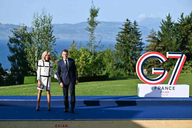 France's President Emmanuel Macron (R) and his wife Brigitte Macron wait for arrival of G7 Heads of State and government for the official greeting during G7 summit, in Evian, eastern France, on June 15, 2026. A G7 summit is set to take place June 15 to 17 in the French town of Evian-les-Bains near Switzerland and it will be attended by country leaders as well as the EU's foreign policy chief and ministers from Brazil, Canada, the United Arab Emirates and Turkey. (Photo by Mandel NGAN / AFP)