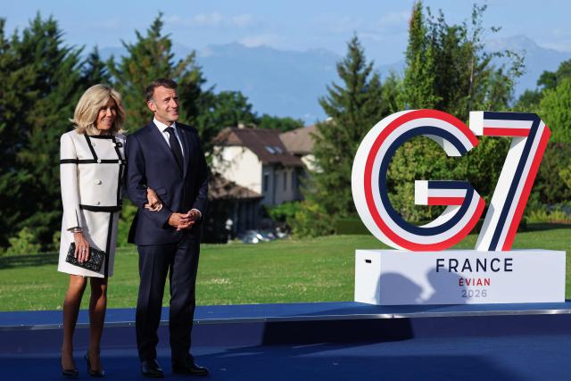 France's President Emmanuel Macron (R) and his wife Brigitte Macron wait for arrival of G7 Heads of State and government for the official greeting during G7 summit, in Evian, eastern France, on June 15, 2026. A G7 summit is set to take place June 15 to 17 in the French town of Evian-les-Bains near Switzerland and it will be attended by country leaders as well as the EU's foreign policy chief and ministers from Brazil, Canada, the United Arab Emirates and Turkey. (Photo by Ludovic MARIN / AFP)