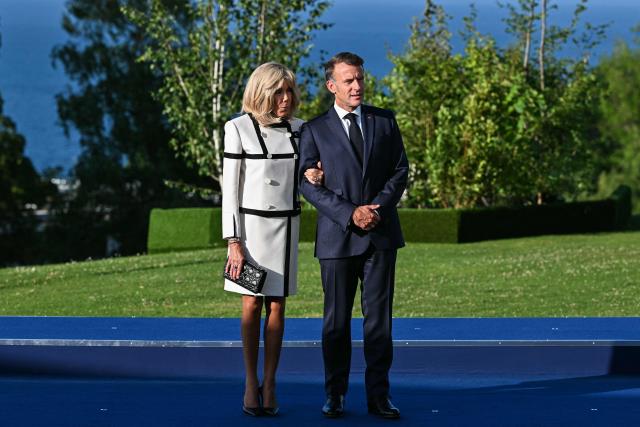 France's President Emmanuel Macron (R) and his wife Brigitte Macron wait for arrival of G7 Heads of State and government for the official greeting during G7 summit, in Evian, eastern France, on June 15, 2026. A G7 summit is set to take place June 15 to 17 in the French town of Evian-les-Bains near Switzerland and it will be attended by country leaders as well as the EU's foreign policy chief and ministers from Brazil, Canada, the United Arab Emirates and Turkey. (Photo by Mandel NGAN / AFP)