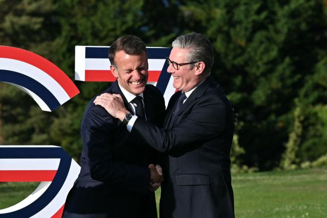 France's President Emmanuel Macron (L) greets Britain's Prime Minister Keir Starmer during the G7 summit, in Evian, eastern France, on June 15, 2026. A G7 summit is set to take place June 15 to 17 in the French town of Evian-les-Bains near Switzerland and it will be attended by country leaders as well as the EU's foreign policy chief and ministers from Brazil, Canada, the United Arab Emirates and Turkey. (Photo by Mandel NGAN / AFP)