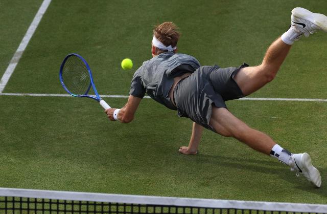 Canada's Denis Shapovalov dives to return a shot during the third set tie-break against Britain's Jack Pinnington Jones during their men's singles round of 32 tennis match on day one of the ATP HSBC Championships at Queen's Club in west London on June 15, 2026. Shapovalov won the match 6-4, 4-6, 7-6. (Photo by Adrian Dennis / AFP)