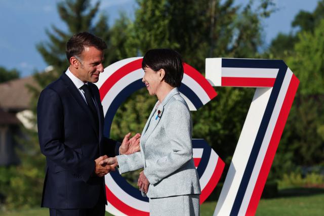 France's President Emmanuel Macron (L) greets Japan's Prime Minister Sanae Takaichi during the official greeting as part of the G7 summit, in Evian, eastern France, on June 15, 2026. A G7 summit is set to take place June 15 to 17 in the French town of Evian-les-Bains near Switzerland and it will be attended by country leaders as well as the EU's foreign policy chief and ministers from Brazil, Canada, the United Arab Emirates and Turkey. (Photo by Ludovic MARIN / AFP)