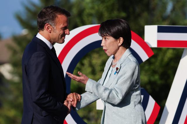 France's President Emmanuel Macron (L) greets Japan's Prime Minister Sanae Takaichi during the official greeting as part of the G7 summit, in Evian, eastern France, on June 15, 2026. A G7 summit is set to take place June 15 to 17 in the French town of Evian-les-Bains near Switzerland and it will be attended by country leaders as well as the EU's foreign policy chief and ministers from Brazil, Canada, the United Arab Emirates and Turkey. (Photo by Ludovic MARIN / AFP)