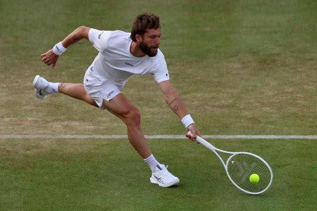 France's Corentin Moutet returns against France's Giovanni Mpetshi Perricard during their men's singles round of 32 tennis match on day one of the ATP HSBC Championships at Queen's Club in west London on June 15, 2026. (Photo by Adrian Dennis / AFP)