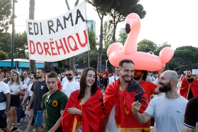 A protestor holds a inflatable flamingo during a demonstration against the construction of a luxury resort near a protected natural area, as they gather in front of Albania's Prime Minister's Office in Tirana on June 15, 2026. Protests have swept Albania for more than two weeks over plans for a luxury hotel project in the protected coastal area of Zvernec, linked to US President Donald Trump's son-in-law Jared Kushner. (Photo by Adnan Beci / AFP)
