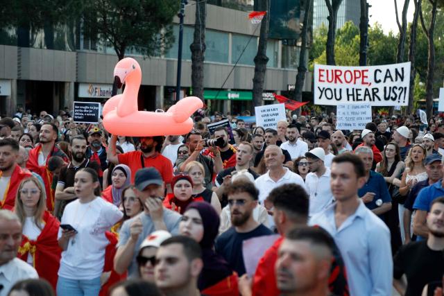 A protestor holds a inflatable flamingo during a demonstration against the construction of a luxury resort near a protected natural area, as they gather in front of Albania's Prime Minister's Office in Tirana on June 15, 2026. Protests have swept Albania for more than two weeks over plans for a luxury hotel project in the protected coastal area of Zvernec, linked to US President Donald Trump's son-in-law Jared Kushner. (Photo by Adnan Beci / AFP)