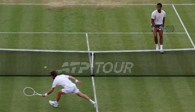 France's Corentin Moutet (L) covers a failed return from France's Giovanni Mpetshi Perricard during their men's singles round of 32 tennis match on day one of the ATP HSBC Championships at Queen's Club in west London on June 15, 2026. (Photo by Adrian DENNIS / AFP)