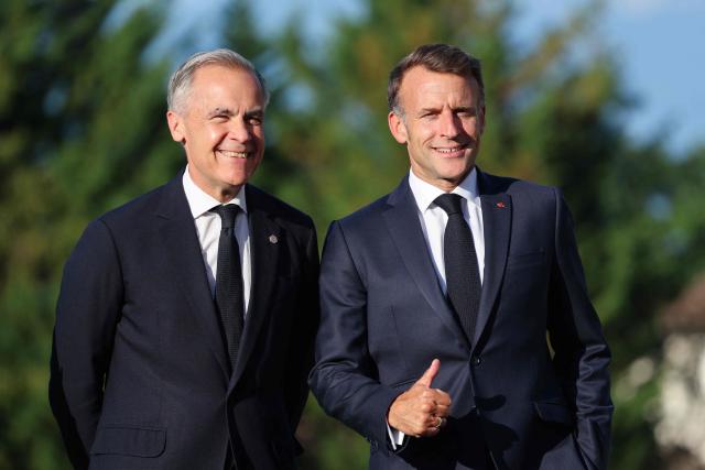 France's President Emmanuel Macron (R) gestures as he greets Canada's Prime Minister Mark Carney during the G7 summit, in Evian, eastern France, on June 15, 2026. A G7 summit is set to take place June 15 to 17 in the French town of Evian-les-Bains near Switzerland and it will be attended by country leaders as well as the EU's foreign policy chief and ministers from Brazil, Canada, the United Arab Emirates and Turkey. (Photo by Ludovic MARIN / AFP)