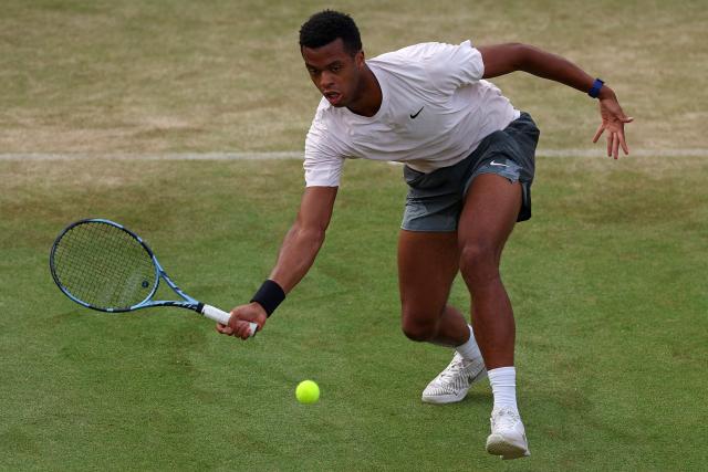 France's Giovanni Mpetshi Perricard returns against France's Corentin Moutet during their men's singles round of 32 tennis match on day one of the ATP HSBC Championships at Queen's Club in west London on June 15, 2026. (Photo by Adrian Dennis / AFP)