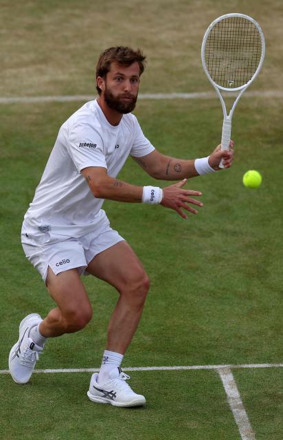 France's Corentin Moutet returns against France's Giovanni Mpetshi Perricard during their men's singles round of 32 tennis match on day one of the ATP HSBC Championships at Queen's Club in west London on June 15, 2026. (Photo by Adrian Dennis / AFP)