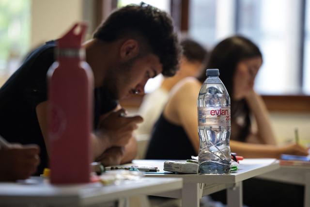 A photograph taken on June 15, 2026 shows a bottle of water as students start working as a 4 hours philosophy dissertation kicks off the French general baccalaureat exam for getting into university, at Bellevue high school, in Toulouse, south-western France. More than 700,000 candidates across France take the 2026 session of the Baccalaureat or "bac", the secondary school diploma required for access to higher education, with written exams running from June 15 to 18 and oral examinations through early July. (Photo by Valentine CHAPUIS / AFP)