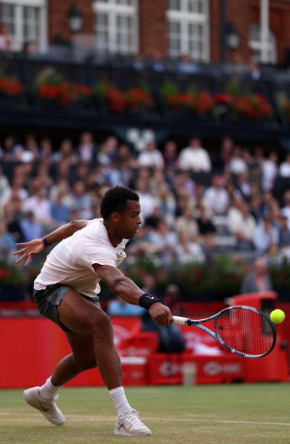 France's Giovanni Mpetshi Perricard returns against France's Corentin Moutet during their men's singles round of 32 tennis match on day one of the ATP HSBC Championships at Queen's Club in west London on June 15, 2026. (Photo by Adrian DENNIS / AFP)