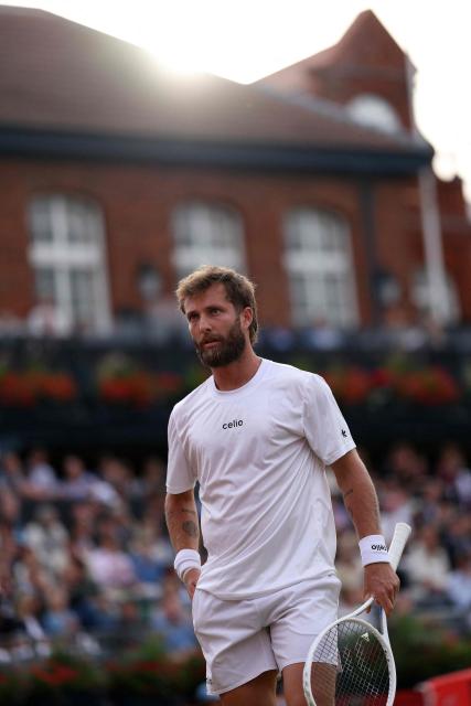 France's Corentin Moutet waits for new balls before serving in the closing stages of the first set, against France's Giovanni Mpetshi Perricard during their men's singles round of 32 tennis match on day one of the ATP HSBC Championships at Queen's Club in west London on June 15, 2026. (Photo by Adrian DENNIS / AFP)
