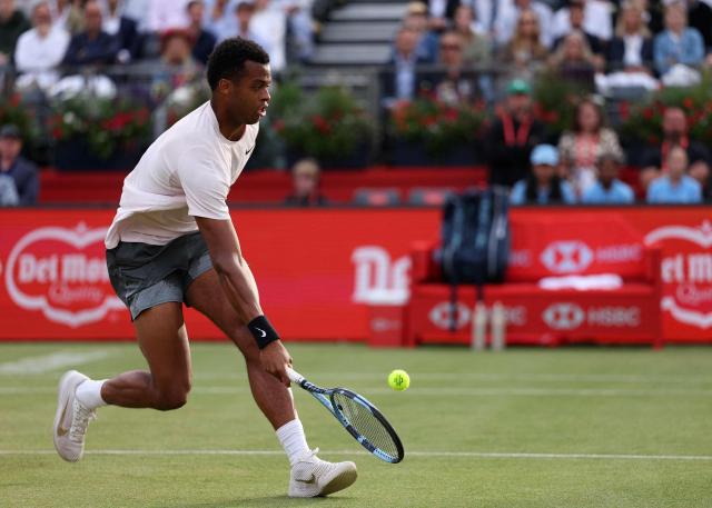 France's Giovanni Mpetshi Perricard returns against France's Corentin Moutet during their men's singles round of 32 tennis match on day one of the ATP HSBC Championships at Queen's Club in west London on June 15, 2026. (Photo by Adrian DENNIS / AFP)