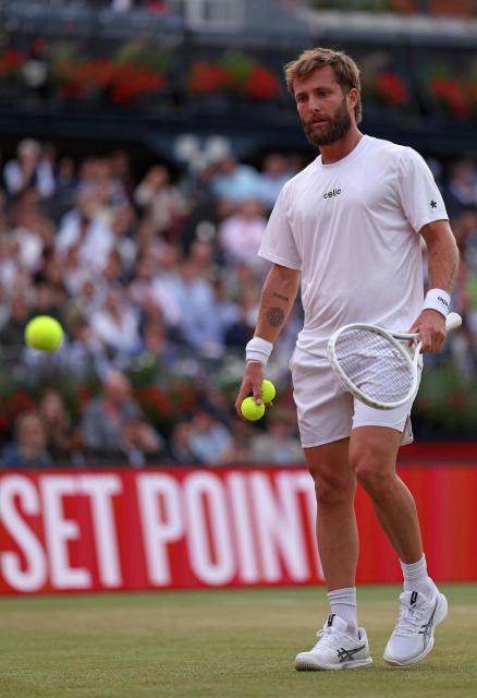France's Corentin Moutet waits for new balls before serving in the closing stages of the first set, against France's Giovanni Mpetshi Perricard during their men's singles round of 32 tennis match on day one of the ATP HSBC Championships at Queen's Club in west London on June 15, 2026. (Photo by Adrian DENNIS / AFP)