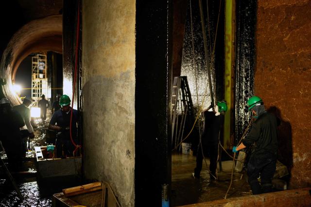 Panama Canal workers carry out routine maintenance inside one of the chambers at the Gatun Locks in the province of Colon, located about 80 kilometers north of Panama City, on June 15, 2026. These maintenance operations are carried out periodically across the interoceanic waterway to ensure the safe and efficient transit of vessels along one of the world's most important and heavily traveled maritime trade routes. (Photo by ARNULFO FRANCO / AFP)