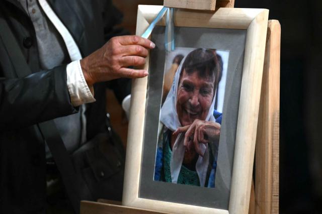 A man touches a picture of Taty Almeida, the late president of the Madres de Plaza de Mayo human rights association, during her wake at the telecommunications union office (FOETRA) in Buenos Aires, on June 15, 2026. Almeida died on June 14, 2026 at the age of 95, after more than four decades as one of the most prominent voices against the crimes of Argentina’s last dictatorship since she lost in 1975 her son Alejandro, a member of the guerrilla group Revolutionary People’s Army (ERP), kidnapped by the right-wing paramilitary organization Triple A.. (Photo by Luis ROBAYO / AFP)