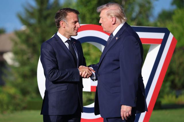 France's President Emmanuel Macron (L) greets US President Donald Trump during the G7 summit, in Evian, eastern France, on June 15, 2026. A G7 summit is set to take place June 15 to 17 in the French town of Evian-les-Bains near Switzerland and it will be attended by country leaders as well as the EU's foreign policy chief and ministers from Brazil, Canada, the United Arab Emirates and Turkey. (Photo by Ludovic MARIN / AFP)