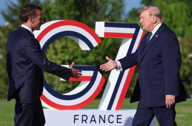 France's President Emmanuel Macron (L) greets US President Donald Trump during the G7 summit, in Evian, eastern France, on June 15, 2026. A G7 summit is set to take place June 15 to 17 in the French town of Evian-les-Bains near Switzerland and it will be attended by country leaders as well as the EU's foreign policy chief and ministers from Brazil, Canada, the United Arab Emirates and Turkey. (Photo by Ludovic MARIN / AFP)