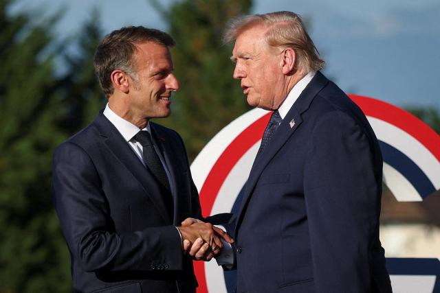 France's President Emmanuel Macron (L) greets US President Donald Trump during the G7 summit, in Evian, eastern France, on June 15, 2026. A G7 summit is set to take place June 15 to 17 in the French town of Evian-les-Bains near Switzerland and it will be attended by country leaders as well as the EU's foreign policy chief and ministers from Brazil, Canada, the United Arab Emirates and Turkey. (Photo by Isabel Infantes / POOL / AFP)
