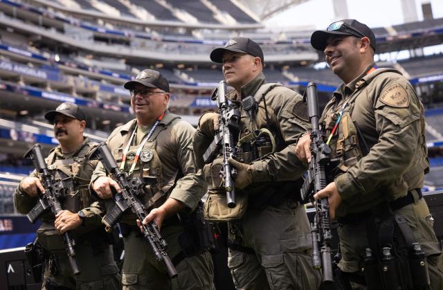 Inglewood police officers with the SWAT unit pose for a photo ahead of the 2026 World Cup Group G football match between Iran and New Zealand at the Los Angeles Stadium in Inglewood on June 15, 2026.  (Photo by ETIENNE LAURENT / AFP)