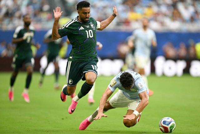 Saudi Arabia's forward #10 Salem Al-Dawsari and Uruguay's defender #03 Sebastian Caceres fight for the ball during the 2026 World Cup Group H football match between Saudi Arabia and Uruguay at the Miami Stadium in Miami Gardens on June 15, 2026.  (Photo by CHANDAN KHANNA / AFP)