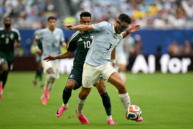 Saudi Arabia's forward #10 Salem Al-Dawsari and Uruguay's defender #03 Sebastian Caceres fight for the ball during the 2026 World Cup Group H football match between Saudi Arabia and Uruguay at the Miami Stadium in Miami Gardens on June 15, 2026.  (Photo by CHANDAN KHANNA / AFP)