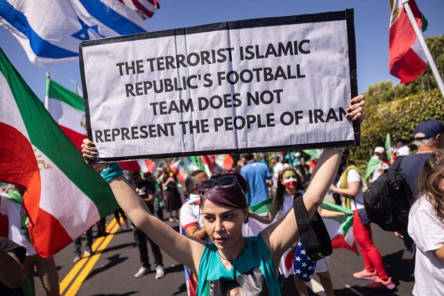 A person holds a sign as they protest against the Iranian regime outside Los Angeles Stadium (SoFi Stadium) ahead of the 2026 World Cup football tournament match between Iran and New Zealand in Inglewood, California, on June 15, 2026. Hundreds of anti-regime protesters gathered outside the stadium in Los Angeles Monday where Iran will take on New Zealand in their opening game of the 2026 World Cup. (Photo by ETIENNE LAURENT / AFP)