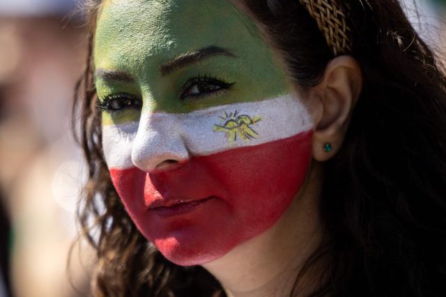 A woman with her face painted joins others as they protest against the Iranian regime outside Los Angeles Stadium (SoFi Stadium) ahead of the 2026 World Cup football tournament match between Iran and New Zealand in Inglewood, California, on June 15, 2026. Hundreds of anti-regime protesters gathered outside the stadium in Los Angeles Monday where Iran will take on New Zealand in their opening game of the 2026 World Cup. (Photo by ETIENNE LAURENT / AFP)