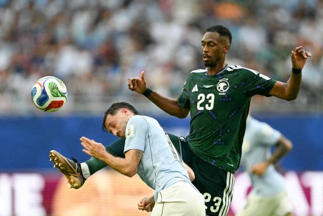 Uruguay's defender #17 Matias Vina and Saudi Arabia's midfielder #23 Mohamed Kanno fight for the ball during the 2026 World Cup Group H football match between Saudi Arabia and Uruguay at the Miami Stadium in Miami Gardens on June 15, 2026.  (Photo by CHANDAN KHANNA / AFP)
