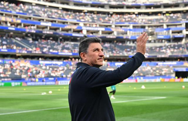 Iran's head coach Amir Ghalenoei waves he walks on the pitch ahead of the 2026 World Cup Group G football match between Iran and New Zealand at Los Angeles Stadium in Inglewood on June 15, 2026.  (Photo by Frederic J. Brown / AFP)
