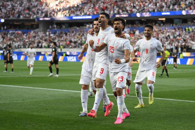 Iran's defender #23 Ramin Rezaeian celebrates with teammates after scoring his team's first goal during the 2026 World Cup Group G football match between Iran and New Zealand at Los Angeles Stadium in Inglewood on June 15, 2026.  (Photo by Patrick T. Fallon / AFP)